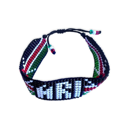 Front view of a beaded bracelet displaying a colorful design with red, white, green, and black beads, showing a detailed geometric pattern.